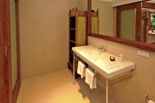 a bathroom with a sink and a mirror at Costabella Tropical Beach Hotel in Mactan
