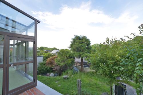 a glass house with a view of a yard at Toya Blue in Lake Toya