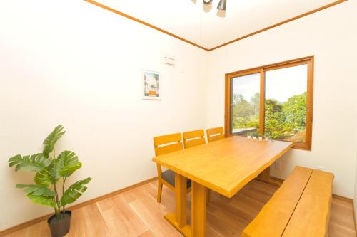 a dining room with a wooden table and a window at Toya Blue in Lake Toya