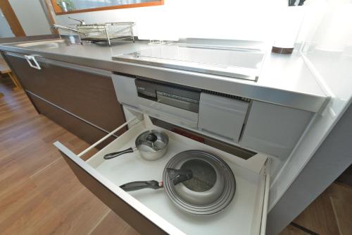 a washing machine in a kitchen under a sink at Toya Blue in Lake Toya