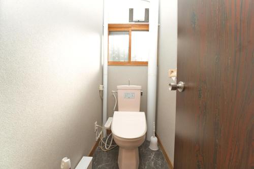 a bathroom with a white toilet in a room at Toya Blue in Lake Toya