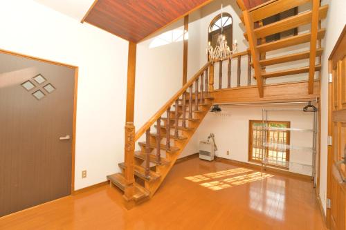 a hallway with a wooden staircase in a house at Toya Blue in Lake Toya