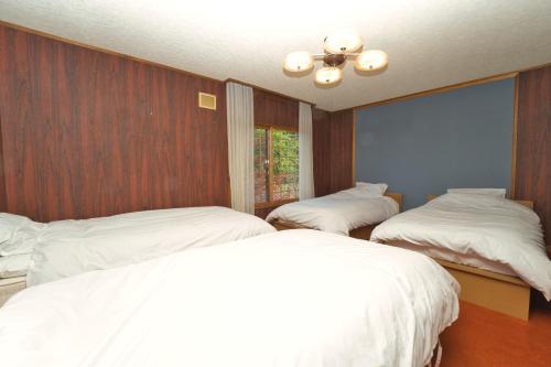 a bedroom with two beds with white sheets at Toya Blue in Lake Toya