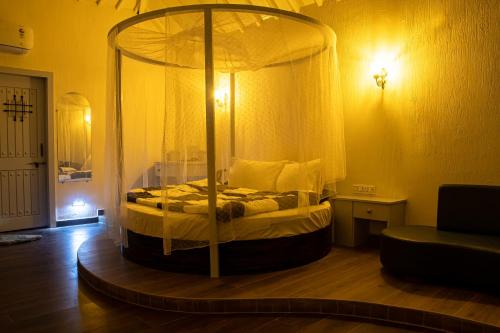 a bedroom with a canopy bed in a room at The Village Resort Mundra in Mundra