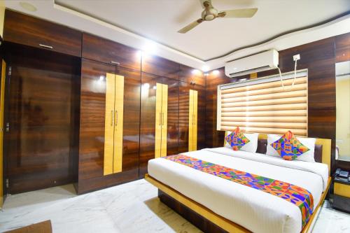 een slaapkamer met een groot wit bed en houten wanden bij FabHotel Divira Inn in Calcutta