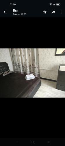 een slaapkamer met een bed met een boek erop bij Уютная двухкомнатная квартира в Актобе in Aqtöbe