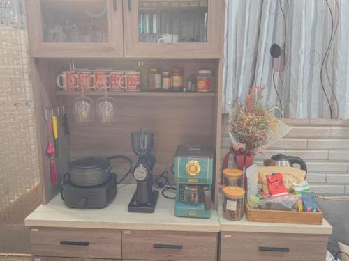 a wooden cabinet with a blender and other kitchen items at Jin Da Paint B&B in Jinning