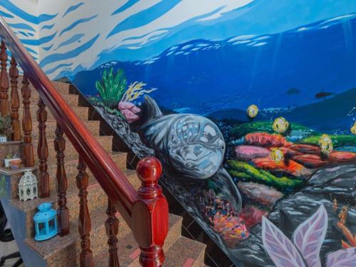 a staircase with a painting on the wall at Jin Da Paint B&B in Jinning
