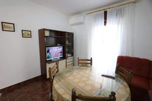 ein Wohnzimmer mit einem Glastisch und einem TV in der Unterkunft Apartments with a parking space Silo, Krk - 18352 in Šilo