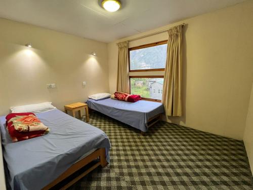 um quarto de hotel com duas camas e uma janela em Hotel Camp de Base em Namche