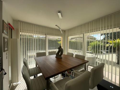 comedor con mesa de madera y sillas en Villa NIKKITA en Lacanau