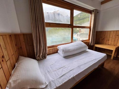 a bed in a room with a large window at Hotel Camp de Base in Namche