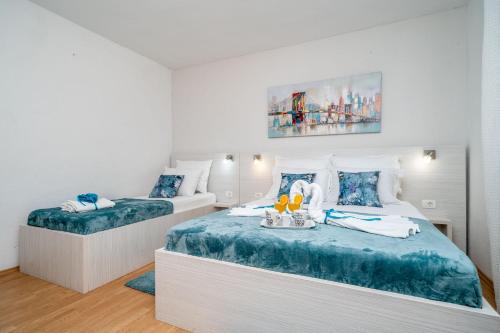 1 dormitorio con 2 camas con sábanas azules y blancas en Family friendly house with a swimming pool Oslje, Dubrovnik - 18381, en Topolo