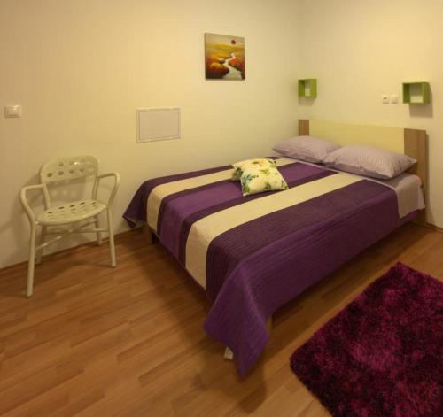 um quarto com uma cama grande e uma cadeira em Rooms by the sea Zadar - 18319 em Zadar