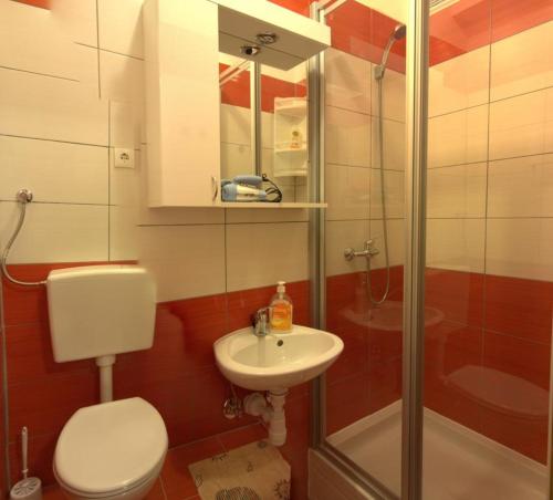 uma casa de banho com um WC, um lavatório e um chuveiro em Rooms by the sea Zadar - 18319 em Zadar