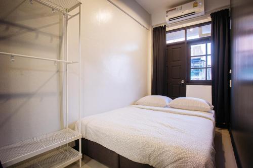 T3 TWO Bedrooms WIFI Full kitchen 1 min to BTS في بانكوك: غرفة نوم صغيرة بها سرير ونافذة