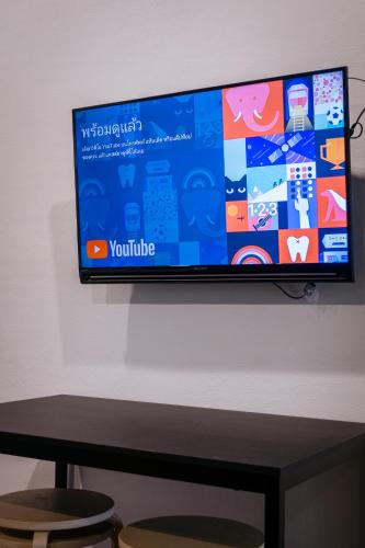 a flat screen tv hanging on a wall at T3 TWO Bedrooms WIFI Full kitchen 1 min to BTS in Bangkok
