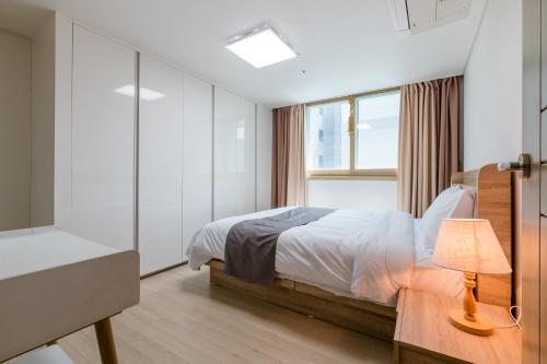 a bedroom with a bed and a window at JS Residence Hotel Okpo in Geoje 