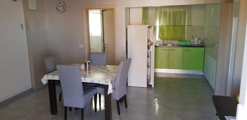 La cuisine est équipée d'une table, de chaises et d'un réfrigérateur. dans l'établissement Apartments with a parking space Vir - 18407, à Vir