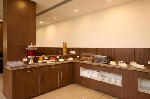 a kitchen with wooden cabinets and aasteryasteryasteryasteryasteryasteryasteryasteryastery at Renest Haridwar in Haridwār