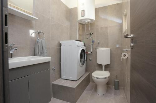 a bathroom with a toilet and a sink at Apartments by the sea Igrane, Makarska - 18405 in Igrane