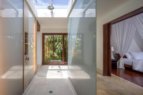 a room with a bed and a glass door at Villa Nusantara in Sanur