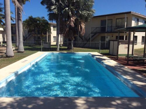 a large blue swimming pool in front of a building at Ocean Breeze Units in Bowen