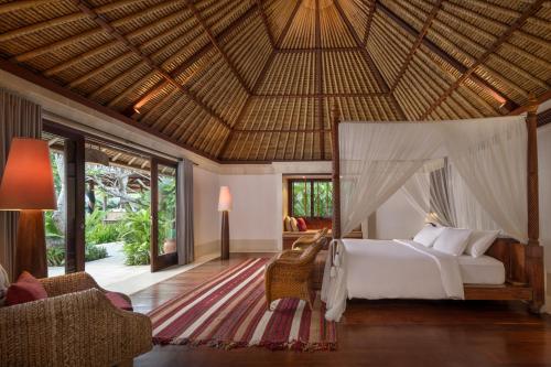 a bedroom with a bed with a canopy in a resort at Villa Nusantara in Sanur