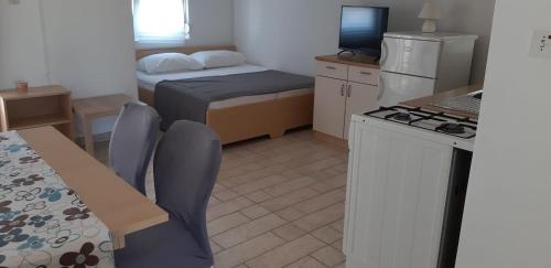 a small room with a kitchen and a bed and a table at Apartments by the sea Nevidjane, Pasman - 18427 in Neviđane