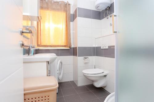 a small bathroom with a toilet and a sink at Apartments with a parking space Split - 18214 in Solin