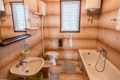 een badkamer met een wastafel, een bad en een toilet bij Apartments with a parking space Medulin - 18463 in Medulin