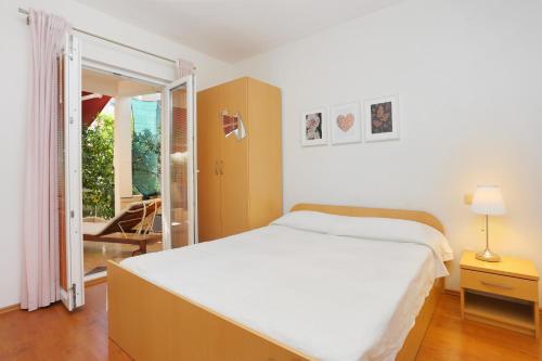 een slaapkamer met een groot bed en een glazen schuifdeur bij Apartments with a parking space Seget Vranjica, Trogir - 18326 in Donji Seget