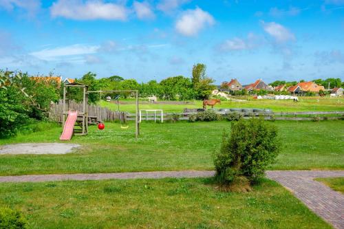 a park with a playground with a swing at Terschelling Natuurlijk in Kinnum