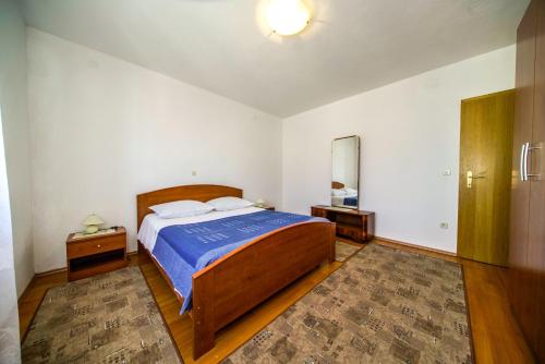 a bedroom with a large bed with a blue blanket at Apartments with parking space Postira, Brac - 18472 in Postira