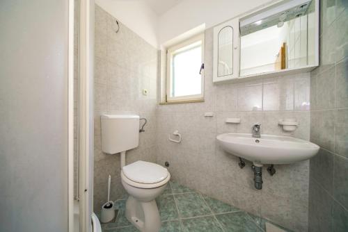 a bathroom with a toilet and a sink at Apartments with parking space Postira, Brac - 18472 in Postira