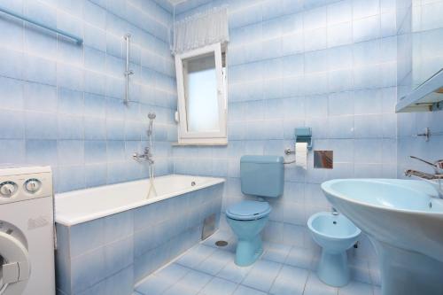 een blauwe badkamer met een toilet en een wastafel bij Apartments by the sea Seget Vranjica, Trogir - 18487 in Donji Seget