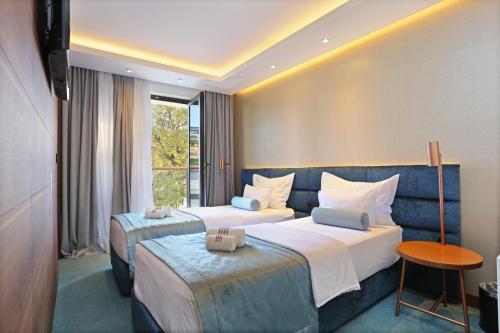 a hotel room with two beds and a television at Rooms with a swimming pool Split - 18489 in Split