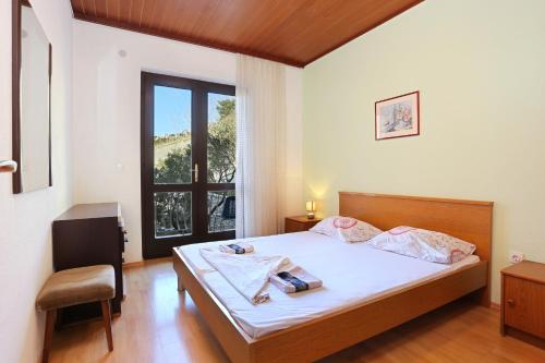 1 dormitorio con cama, escritorio y ventana en Apartments with a parking space Brela, Makarska - 18495 en Brela