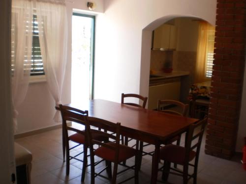 une salle à manger avec une table et des chaises et une fenêtre dans l'établissement Apartments by the sea Pag - 18464, à Pag