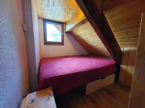 Cette petite chambre dispose d'un lit rouge dans un escalier. dans l'établissement Mas du Peyron, à Saint-Chaffrey