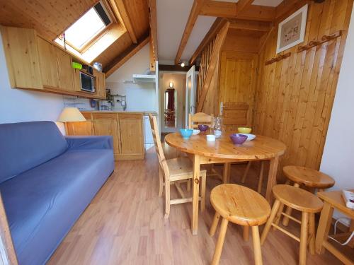 un salon avec une table et un canapé bleu dans l'établissement Mas du Peyron, à Saint-Chaffrey