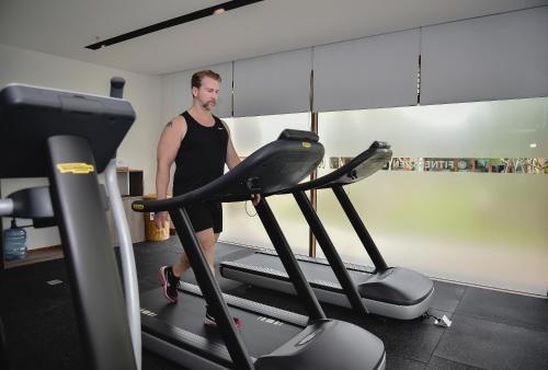a man walking on a treadmill in a gym at The Ocean Villas Managed by The Ocean Resort in Da Nang