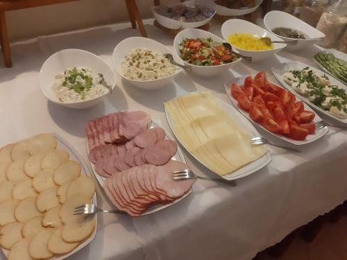 Una mesa con muchos tipos diferentes de comida sobre ella. en Hotel & Restauracja Glass, en Radom