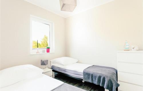 ドンプキにある2 Bedroom Cozy Home In Dabkiの白い部屋 ベッド2台 窓付