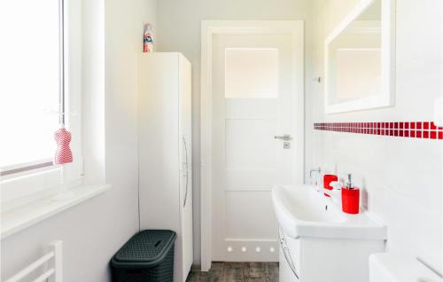 a white bathroom with a sink and a toilet at Nice Home In Dabki With 2 Bedrooms, Wifi And Outdoor Swimming Pool in Dąbki