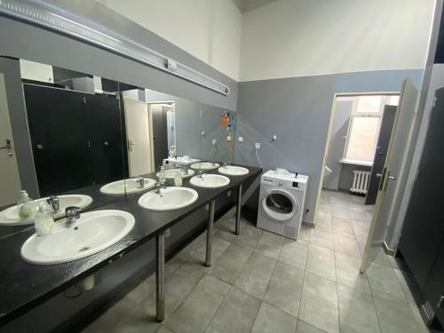 a bathroom with four sinks and a washing machine at Oliwka Hostel in Warsaw