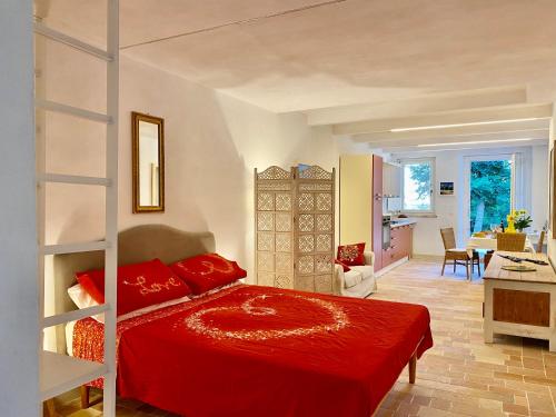 um quarto com uma cama vermelha e uma sala de estar em Al Teatro di Tavignano em Cingoli