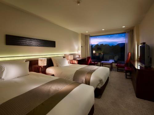 a hotel room with two beds and a large window at The Prince Karuizawa in Karuizawa