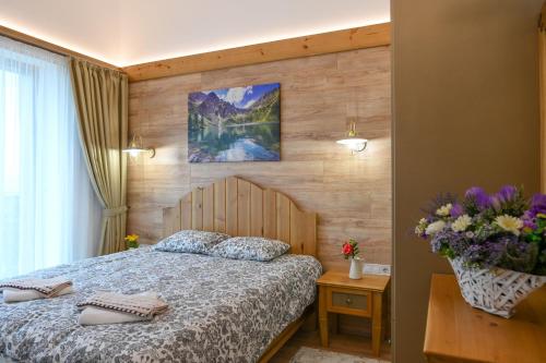 a bedroom with a bed and a wooden wall at Villa Letizia near the Bansko Ski Resort in Razlog