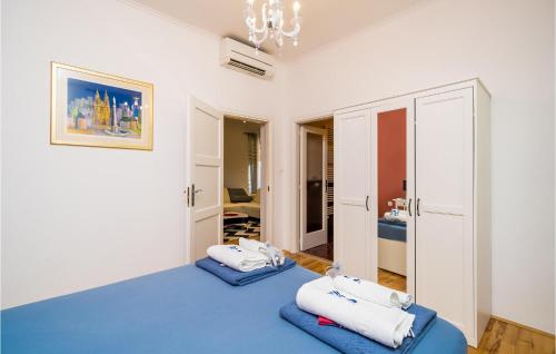 Habitación con 2 camas azules y lámpara de araña. en Nice Home In Gruda With Kitchen, en Gruda